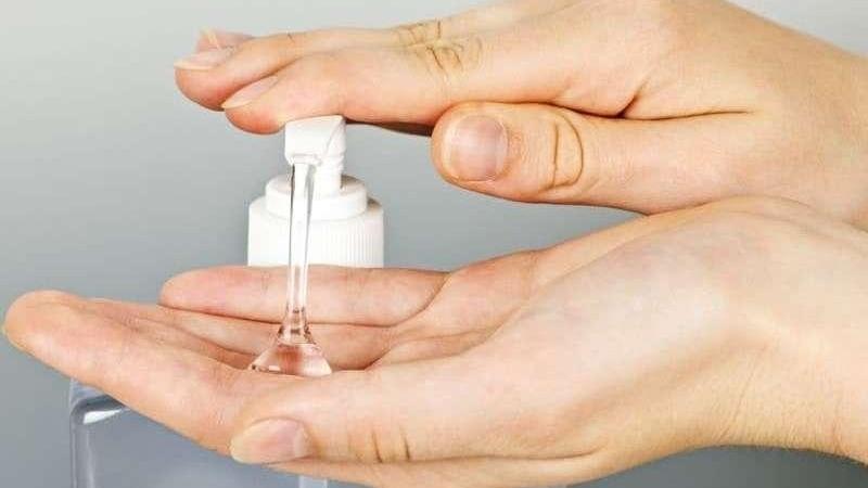 person using hand sanitizer in Northcote