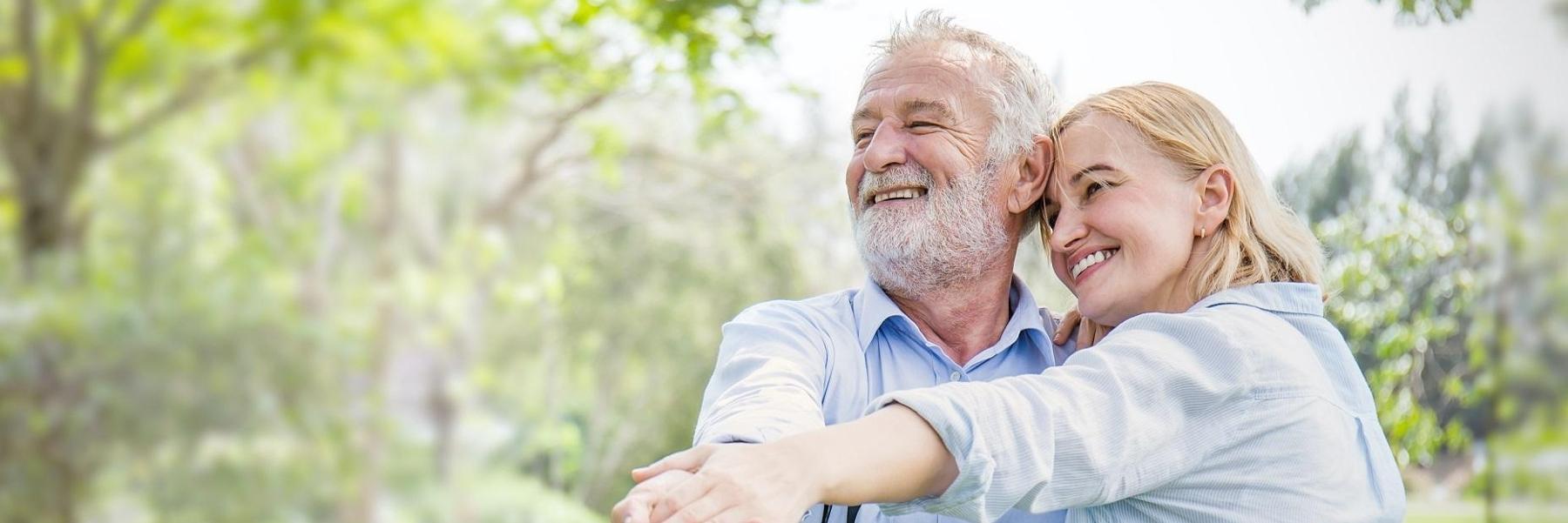 older man and woman smiling after getting dentures